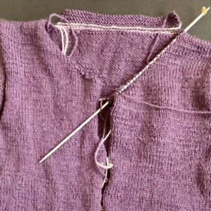 Foto mit einem gestrickten Teil einer Babyjacke